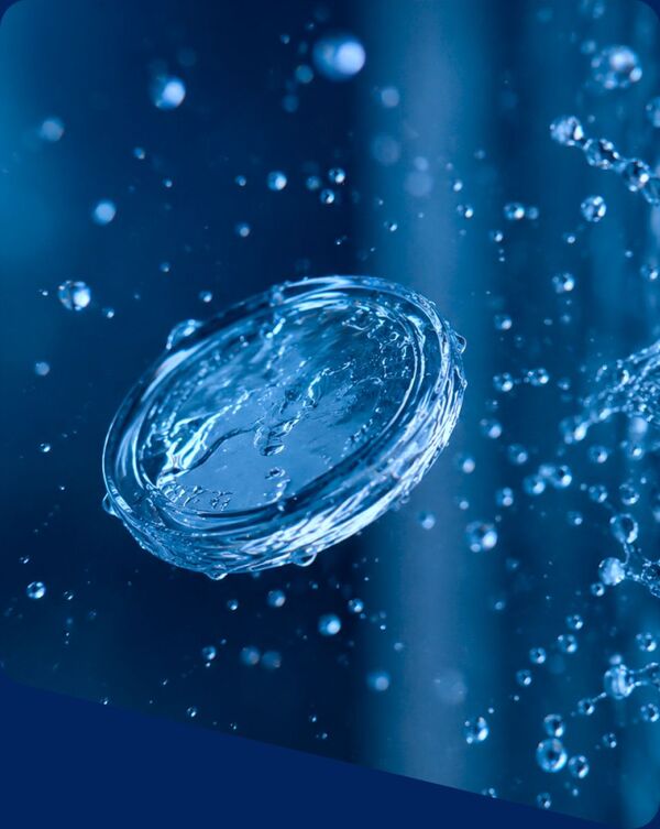 A single water droplet suspended mid-splash against deep blue water